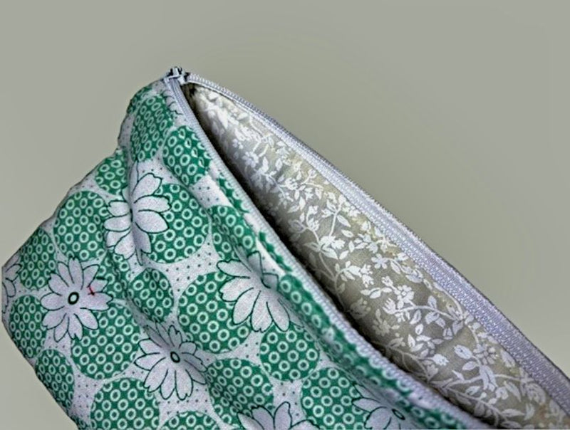 The Green Daisy Print Pouch has a tan lining with white flowers. Made in the USA for Harvest Array.