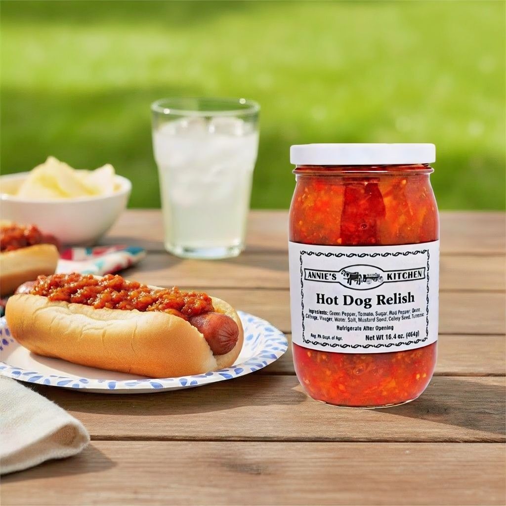 Labor Day Picnic Food. Picnic table with a hotdog on a plate, a glass of lemonade, and a jar of Annie's Hot Dog Relish